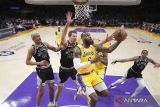 Pebasket Los Angeles Russel LeBron James (6) memasukan bola ke basket melewati pebasket San Antonio Spurs Jeremy Sochan (10) dan Jakob Poeltl (25) pada pertandingan bola basket NBA di Crypto.com Arena, Los Angeles, California, Amerika Serikat, Rabu (25/1/2023). Lakers menang 113-104 atas tamunya Spurs. ANTARA FOTO/USA TODAY Sports/Kirby Lee/wsj.