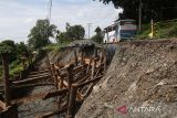 Kendaraan  melintas di salah satu ruas jalan nasional yang amblas di jalur  Banda Aceh-Medan kilometer  71 di desa Sare,  kabupaten Aceh Besar  Aceh, Jumat (27/1/2023). Dinas Pekerjaan Umum dan Penataan Ruang, provinsi Aceh mulai memperbaiki tiga lokasi badan jalan nasional yang amblas akibat tingginya intensitas hujan guna memperlancar arus kendaraan dari Banda Aceh-Medan. ANTARA FOTO/Ampelsa.