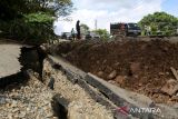 Kendaraan  melintas di salah satu ruas jalan nasional yang amblas di jalur  Banda Aceh-Medan kilometer 81 di desa Simpang Beutong, kecamatan Muara Tiga, kabupaten Pidie, Aceh, Jumat (27/1/2023). Dinas Pekerjaan Umum dan Penataan Ruang, provinsi Aceh mulai memperbaiki tiga lokasi badan jalan nasional yang amblas akibat tingginya intensitas hujan guna memperlancar arus kendaraan dari Banda Aceh-Medan. ANTARA FOTO/Ampelsa.