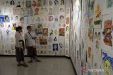 Pengunjung mengamati karya lukisan di atas kertas saat Pameran 