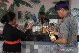 Pekerja menata produk arak Bali yang dipamerkan saat perayaan Hari Arak Bali di Bali Collection, Nusa Dua, Badung, Bali, Minggu (29/1/2023). Kegiatan tersebut digelar dalam upaya memperkokoh perlindungan dan pemberdayaan arak Bali sesuai Peraturan Gubernur Bali Nomor 1 Tahun 2020 tentang tata kelola minuman fermentasi dan/atau destilasi khas Bali sebagai tonggak perubahan status yang mengangkat keberadaan, nilai, dan harkat arak Bali yang bertujuan melindungi dan memelihara arak sesuai dengan nilai-nilai budaya serta memberdayakan, memasarkan, dan memanfaatkan minuman tersebut sebagai ekonomi rakyat yang berkelanjutan. ANTARA FOTO/Nyoman Hendra Wibowo/wsj.