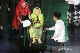 Istri Presiden ke-4 RI Sinta Nuriyah (tengah) mewakili Presiden ke-4 RI Abdurrahman Wahid menerima penghargaan kategori nasional yang diberikan oleh Ketua PBNU KH Yahya Cholil Staquf (kanan) saat Anugerah Satu Abad NU di Theater Indonesia, TMII, Jakarta, Selasa (31/1/2023) malam. Pengurus Besar Nahdlatul Ulama (PBNU) menggelar malam Anugerah Satu Abad NU sebagai ajang pemberian penghargaan kepada pihak-pihak yang berjasa dalam membesarkan NU. ANTARA FOTO/Asprilla Dwi Adha/tom. 