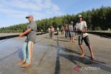 Sejumlah nelayan tradisional menyortir ikan hasil tangkapan pukat darat tradisional di pantai Desa Suak Timah, Kecamatan Samatiga, Aceh Barat, Aceh, Rabu (1/2/2023). Hasil tangkapan nelayan pukat darat tradisional yang biasanya mencapai 55 kilogram dalam sekali tangkap, sejak sepekan terakhir menurun sekitar 50 persen akibat pengaruh cuaca di perairan barat dan selatan Aceh. ANTARA Aceh/Syifa Yulinnas