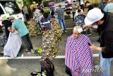 Sejumlah warga menyukur rambut mereka untuk memperingati Hari Kanker Sedunia di Kota Banda Aceh, Aceh, Minggu (5/2/2023). Gabungan dari organisasi profesi seperti IDI, relawan hingga komunitas Aceh Barber Seupakat memperingati hari kanker sedunia untuk menunjukan solidaritas terhadap penderita kanker dan mengingatkan masyarakat untuk mencegah penyakit mematikan tersebut. Antara Aceh/FB Anggoro