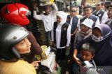  Gubernur Jawa Timur Khofifah Indar Parawansa (ketiga kiri) berbincang dengan pembeli saat meninjau pelaksanaan stabilisasi pasokan dan harga pangan beras di Pasar Larangan Sidoarjo, Jawa Timur, Minggu (5/2/2023). Pemprov Jawa Timur bersama Bulog menggelar stabilisasi pasokan dan harga pangan beras di sejumlah pasar di berbagai daerah di Jawa Timur dengan menjual beras Rp45 ribu per lima kilogram. ANTARA Jatim/Umarul Faruq/zk