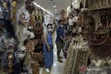 Wisatawan melihat kerajinan khas Bali yang dijual di Pasar Seni Sukawati, Gianyar, Bali, Selasa (7/2/2023). Badan Pusat Statistik Provinsi Bali mencatat pertumbuhan ekonomi Bali pada Januari-Desember 2022 tumbuh sebesar 4,84 persen. ANTARA FOTO/Nyoman Hendra Wibowo/wsj.