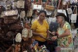 Pedagang melayani wisatawan mancanegara yang memilih kerajinan khas Bali saat berkunjung ke Pasar Seni Sukawati, Gianyar, Bali, Selasa (7/2/2023). Badan Pusat Statistik Provinsi Bali mencatat pertumbuhan ekonomi Bali pada Januari-Desember 2022 tumbuh sebesar 4,84 persen. ANTARA FOTO/Nyoman Hendra Wibowo/wsj.