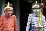 Dua anak dengan riasan warna-warni mengikuti ritual Ngerebeg di Desa Tegallalang, Gianyar, Bali, Rabu (8/2/2023). Tradisi itu dilakukan warga setempat dengan berkeliling kampung dan mengenakan riasan tubuh menyerupai mahluk menyeramkan untuk menciptakan keharmonisan sekaligus sebagai penolak bala. ANTARA FOTO/Fikri Yusuf/wsj.