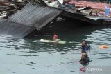 Sejumlah polisi mencari korban di reruntuhan bangunan rumah makan yang tenggelam akibat gempa bumi di Jayapura, Papua, Kamis (9/2/2023). Badan Nasional Penanggulangan Bencana (BNPB) melaporkan empat warga meninggal dunia dan sejumlah bangunan mengalami kerusakan akibat gempa bumi berkekuatan 5,4 Magnitudo tersebut. ANTARA FOTO/Gusti Tanati/wsj.