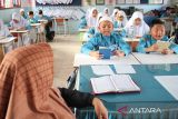 Sejumlah murid menggelar tradisi Jumat Yasinan sebelum mengikuti proses belajar di Sekolah Dasar Negeri 20, Banda Aceh, Aceh, Jumat (10/2/2023).  Pemerintah provinsi Aceh menerapkan budaya  membaca Surat Yasin setiap Jumat sebelum dimulai proses belajar mengajar itu merupakan bagian dari pendidikan karakter  anak di sekolah.  ANTARA FOTO.Ampelsa.