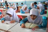 Sejumlah murid menggelar tradisi Jumat Yasinan sebelum mengikuti proses belajar di Sekolah Dasar Negeri 20, Banda Aceh, Aceh, Jumat (10/2/2023).  Pemerintah provinsi Aceh menerapkan budaya  membaca Surat Yasin setiap Jumat sebelum dimulai proses belajar mengajar itu merupakan bagian dari pendidikan karakter  anak di sekolah.  ANTARA FOTO.Ampelsa.