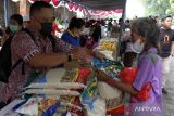 Pedagang melayani warga yang membeli beras saat operasi pasar murah di Denpasar, Bali, Jumat (10/2/2023). Kegiatan yang digelar oleh Pemerintah Kota Denpasar tersebut untuk mengendalikan inflasi daerah serta membantu meringankan beban masyarakat. ANTARA FOTO/Nyoman Hendra Wibowo/wsj.