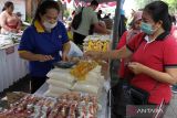 Pedagang melayani warga yang membeli minyak goreng saat operasi pasar murah di Denpasar, Bali, Jumat (10/2/2023). Kegiatan yang digelar oleh Pemerintah Kota Denpasar tersebut untuk mengendalikan inflasi daerah serta membantu meringankan beban masyarakat. ANTARA FOTO/Nyoman Hendra Wibowo/wsj.