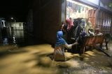 Warga melintasi banjir di Gampong Teupin Batee, Kecamatan Blang Bintang, Aceh Besar, Aceh, Jumat (10/2/2023). ANTARA Aceh/Khalis Surry