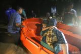 Warga yang berhasil dievakuasi menggunakan perahu setelah terjebak banjir di Gampong Teupin Batee, Kecamatan Blang Bintang, Aceh Besar, Aceh, Sabtu (11/2/2023). ANTARA Aceh/Khalis Surry