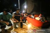 Petugas BPBD dan warga membantu mengevakuasi warga yang terjebak banjir menggunakan perahu di Gampong Teupin Batee, Kecamatan Blang Bintang, Aceh Besar, Aceh, Sabtu (11/2/2023). ANTARA Aceh/Khalis Surry