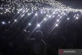 Penonton menyalakan lampu ponselnya saat menyaksikan konser boyband Westlife yang bertajuk 