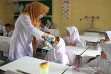 Petugas kesehatan memberikan vaksin polio tetes (Oral Poliomyelitis Vaccine) tahap dua kepada pelajar  di Sekolah Dasar Negeri 7, Banda Aceh, Aceh, Kamis (13/2/2023). Pemerintah provinsi Aceh menggelar vaksin polio tahap dua secara serentak di sejumlah kabupaten/kota  dengan target capaian sebanyak 1,2 juta anak pada tahaun 2023. ANTARA FOTO/Ampelsa.
