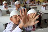 Murid sekolah memperlihatkan jari mereka yang sudah dicap tinta sebagai tanda memperoleh vaksin polio (Oral Poliomyelitis Vaccine) tahap dua di Sekolah Dasar Negeri 7, Banda Aceh, Aceh, Kamis (13/2/2023). Pemerintah provinsi Aceh menggelar vaksin polio tahap dua secara serentak di sejumlah kabupaten/kota  dengan target capaian sebanyak 1,2 juta anak pada tahaun 2023. ANTARA FOTO/Ampelsa.