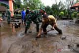 Guru bersama prajurit TNI dan relawan membersihkan material lumpur yang terbawa banjir di halaman SDN Sempol 1, Bondowoso, Jawa Timur, Senin (13/2/2023). Banjir bandang yang terjadi pada Minggu (12/2) malam itu merendam sekolahan tersebut sehingga proses belajar mengajar diliburkan sementara. ANTARA Jatim/Budi Candra Setya/zk