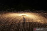 Seorang anggota Komunitas fotografi GeoAceh memainkan kreasi lukisan cahaya (light painting) di pantai wisata Kutaraja, Banda Aceh, Aceh, Minggu (12/2/2023). Light painting merupakan kreasi foto dengan menggunakan kecepatan rana (shutter speed) lambat hingga dapat merekam garis cahaya yang dibuat dengan berbagai bentuk. ANTARA FOTO/Irwansyah Putra/wsj.