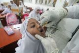 Petugas kesehatan memberikan tetesan vaksin polio (Oral Poliomyelitis Vaccine) tahap dua kepada pelajar di Sekolah Dasar Negeri 3, Lhokseumawe, Aceh, Rabu (15/2/2023). Antara Aceh/Rahmad.
