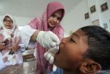 Petugas kesehatan memberikan tetesan vaksin polio (Oral Poliomyelitis Vaccine) tahap dua kepada pelajar di Sekolah Dasar Negeri 3, Lhokseumawe, Aceh, Rabu (15/2/2023). Antara Aceh/Rahmad.
