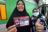 Seorang warga menunjukan stiker hasil kerja Petugas Pemutakhiran Data Pemilih (Pantarlih) usai melakukan pencocokan dan penelitian (Coklit) data pemilih Pemilu 2024 di rumah warga Desa Ujong Blang, Lhokseumawe, Aceh, Rabu (15/2/2023). Coklit serentak data pemilih hingga 14 Maret 2023 itu bertujuan untuk mencocokkan secara detail data pemilih yang ada di KPU/KIP dengan data pemilih asli di lapangan untuk mengantisipasi ketidaksesuaian data pemilih pada Pemilu 2024. Antara Aceh/Rahmad