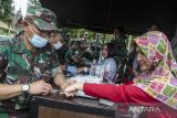 Anggota TNI menyuntikkan vitamin C kepada warga saat penyaluran bantuan di Dodik Bela Negara Rindam III Siliwangi, Lembang, Kabupaten Bandung Barat, Jawa Barat, Rabu (15/2/2023). Kantor Staf Kepresidenan menyalurkan sebanyak 2,5 juta ampul vitamin C hasil bantuan dari pengusaha sektor kesehatan untuk disuntikan kepada masyarakat sebagai penguat imunitas di masa peralihan pandemi menjadi endemi. ANTARA FOTO/Novrian Arbi/agr