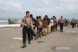 Pesonil Polri  dan TNI mengawal  imigran etnis Rohingya menuju mobil angkutan untuk dipindahkan ke lokasi penampungan sementara usai terdampar di Desa Lampanah Leugah, Kecamatan Seulimeuem, Aceh Besar, Aceh, Kamis (16/2/2023). Sebanyak 62 orang imigran etnis Rohingya terdiri dari 23 orang laki-laki dewasa , 21 orang perempuan dewasa  dan 18 orang anak-anak menaiki perahu  terdampar di pantai Desa Lampanah Leugah, kabupaten Aceh Besar. ANTARA FOTO/Ampelsa.