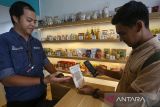 Pembeli bertransaksi menggunakan layanan Quick Response Code Indonesian Standar (QRIS) di UMKM Center Banda Aceh, Aceh, Kamis (16/2/2023). Antara Aceh/Khalis Surry