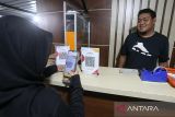 Pembeli bertransaksi menggunakan layanan Quick Response Code Indonesian Standar (QRIS) di salah satu warung kopi di Banda Aceh, Aceh, Kamis (16/2/2023). Antara Aceh/Khalis Surry