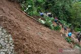 Sejumlah warga bersama prajurit TNI membersihkan reruntuhan tanah yang menimbun jalan di Padas, Dagangan, Kabupaten Madiun, Jawa Timur, Jumat (17/2/2023). Hujan deras di wilayah tersebut mengakibatkan tebing longsor dan menimbun jalan, Kamis (16/2). ANTARA Jatim/Siswowidodo/ZK