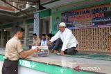 Seorang guru memberikan sumbangan saat berlangsung penggalangan dana  di Sekolah Madrasyah Tsanawiyah Negeri (MTsN ) Model,  Banda Aceh, Aceh, Jumat (17/2/2023). Aksi penggalangan dana dan doa bersama di sekolah tersebut merupakan bentuk solidaritas pelajar untuk  korban gempa bumi di Turki. ANTARA FOTO/Ampelsa.