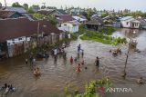 Sejumlah warga bermain air saat air pasang di Banjarmasin, Kalimantan Selatan, Minggu (19/2/2023). Berdasarkan prakiraan Badan Meteorologi, Klimatologi dan Geofisika (BMKG) Kalimantan Selatan dengan adanya fenomena fase bulan baru, mengakibatkan sejumlah wilayah di Kota Banjarmasin, terutama di daerah bantaran sungai, terdampak air pasang laut atau banjir rob yang akan berlangsung dari 18- 24 Februari. ANTARA/ Bayu Pratama S.