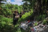 Masyarakat adat Cireundeu berjalan menuju titik longsor di bekas TPA Leuwigajah untuk menabur bunga dalam rangka Hari Peduli Sampah Nasional (HPSN) di Cimahi, Jawa Barat, Selasa (21/2/2023). Aksi tabur bunga tersebut dilakukan dalam rangka memperingati HPSN serta 18 tahun tragedi longsornya sampah di TPA Leuwigajah yang menewaskan 157 orang. ANTARA FOTO/Raisan Al Farisi/agr