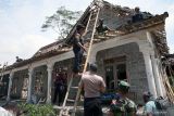  Anggota KODIM0808/Blitar dan Polres Blitar Kota membantu warga memperbaiki rumah yang rusak akibat ledakan di Desa Karangbendo Kecamatan Ponggok, Blitar, Rabu (22/2/2023). Berdasarkan hasil pendataan terperinci BPBD setempat, jumlah kerusakan akibat terdampak ledakan yang terjadi pada Minggu (19/2/2023) malam lalu bertambah dari yang sebelumnya terdapat 25 bangunan, menjadi total terdapat 34 bangunan rusak  dengan rincian 22 rumah rusak ringan, 8 rumah rusak sedang, 3 rumah rusak berat, serta satu mushalla rusak ringan. ANTARA Jatim/Irfan Anshori/zk 