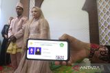 Petugas Kantor Urusan Agama (KUA) Ulee Kareng memperlihatkan kartu nikah digital milik sepasang pengantin usai melaksanakan akad nikah di Banda Aceh, Aceh, Kamis (23/2/2023). Antara Aceh/Khalis Surry