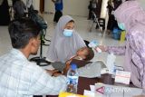 Petugas kesehatan memeriksa kesehatan anak imigran etnis Rohingya sebelum diberikan vaksin campak (rubella) dan vitamin A kepada anak imigran etnis Rohingya yang baru ditempatkan di penampungan sementara UPTD Rumoh Sejahtera Dinas Sosial, Desa Ladong, Kabupaten Aceh Besar, Aceh, Jumat (24/2/2023). Sebanyak 69 imigran etnis Rohingya yang baru ditempatkan di penampungan sementara itu, terdiri dari anak anak anak sebanyak 20 orang mendapatkan vaksin campak dan vitamin A, sedangkan imigran dewasa berjumlah 49 orang menjalani pemeriksaan kesehatan .ANTARA FOTO/Ampelsa.