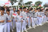 Pelajar mengibarkan bendera merah putih saat menyambut pawai Piala Adipura 2022 di Jalan Simpang Kodim, Banda Aceh, Aceh, Rabu (1/3/2023).  Antara Aceh/Khalis Surry