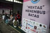 Pendamping membantu penyandang disabilitas untuk mengikuti peringatan Hari Kursi Roda Internasional di Kiara Artha Park,  Bandung, Jawa Barat, Rabu (1/3/2023). Peringatan Hari Kursi Roda Internasional yang diadakan oleh Forum Perjuangan Difabel dengan tema 