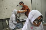 Pelajar menjalani cek mata saat pemeriksaan penyakit tidak menular (PTM) di SMPN 21, Bandung, Jawa Barat, Kamis (2/3/2023). Pemeriksaan PTM yang digelar Dinas Kesehatan Kota Bandung tersebut diprioritaskan untuk penyakit diabetes melitus, hipertensi, dan mata guna deteksi dini serta pemantauan faktor risiko penyakit tidak menular pada kelompok umur 15-19 tahun. ANTARA FOTO/Raisan Al Farisi/agr