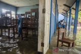 Murid membersihkan ruangan kelas yang terendam banjir di SMPN 1 Telukjambe Barat, Karangligar, Kabupaten Karawang, Jawa Barat, Jumat (3/3/2023). Sekolah tersebut menjadi salah satu fasilitas pendidikan yang terendam setinggi 30 cm hingga 1,5 meter akibat banjir yang melanda sejak senin (27/2) sehingga mengganggu jalannya aktivitas pedidikan. ANTARA FOTO/Novrian Arbi/agr