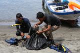 Warga memasukkan sampah ke dalam kantong yang diambil dari dalam laut Pantai Kuta Timu, Kota Sabang, Aceh, Sabtu (4/3/2023). Antara Aceh/Khalis Surry