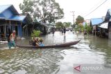 Warga menggunakan perahu melintasi jalan yang terendam banjir di Desa Sungai Rangas Ulu, Kabupaten Banjar, Kalimantan Selatan, Sabtu (4/3/2023). Berdasarkan data Pusdalops Badan Nasional Penanggulangan Bencana (BNPB) mencatat sebanyak 1.826 Kepala Keluarga atau 6.440 jiwa terdampak banjir di enam Kecamatan di Kabupaten Banjar. ANTARA/Bayu Pratama S.
