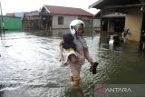 Warga melintasi banjir di Desa Sungai Rangas Ulu, Kabupaten Banjar, Kalimantan Selatan, Sabtu (4/3/2023). Berdasarkan data Pusdalops Badan Nasional Penanggulangan Bencana (BNPB) mencatat sebanyak 1.826 Kepala Keluarga atau 6.440 jiwa terdampak banjir di enam Kecamatan di Kabupaten Banjar. ANTARA/Bayu Pratama S.