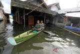 Warga menggunakan perahu saat keluar rumahnya yang terendam banjir di Desa Sungai Rangas Ulu, Kabupaten Banjar, Kalimantan Selatan, Minggu (5/3/2023). Badan Penanggulangan Bencana Daerah (BPBD) Kabupaten Banjar mencatat sejak 25 Februari hingga 4 Maret 2023, sebanyak 65.784 jiwa dan 17.257 rumah di 99 desa dan kelurahan terdampak banjir di Kabupaten Banjar. ANTARA/Bayu Pratama S.