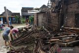 Sejumlah warga dan relawan memindahkan reruntuhan atap rumah yang ambruk akibat terjangan angin kencang di Desa Plumpung Rejo, Wonoasri, Kabupaten Madiun, Jawa Timur, Senin (6/3/2023). Hujan deras disertai angin kencang pada Minggu (5/3) mengakibatkan ratusan rumah rusak dan satu di antaranya roboh serta puluhan pohon tumbang. ANTARA Jatim/Siswowidodo/ZK