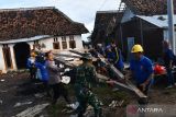 Sejumlah warga bersama prajurit TNI, polisi dan relawan memindahkan reruntuhan atap rumah yang ambruk akibat terjangan angin kencang di Desa Plumpung Rejo, Wonoasri, Kabupaten Madiun, Jawa Timur, Senin (6/3/2023). Hujan deras disertai angin kencang pada Minggu (5/3) mengakibatkan ratusan rumah rusak dan satu di antaranya roboh serta puluhan pohon tumbang. ANTARA Jatim/Siswowidodo/zk