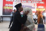 Narapidana kasus pencabulan Yanto (kiri) mencium kening istrinya Wiwik Ariamti Subani (kanan) usai melakukan prosesi ijab kabul di Lembaga Pemasyarakatan (Lapas) Klas IIA Kedirii, Jawa Timur, Selasa (7/3/2023). Narapidana yang dihukum penjara selama 14 tahun dan baru menjalani hukuman selama 4 tahun tersebut menikah dengan kekasihnya di lapas. ANTARA Jatim/Prasetia Fauzani/zk